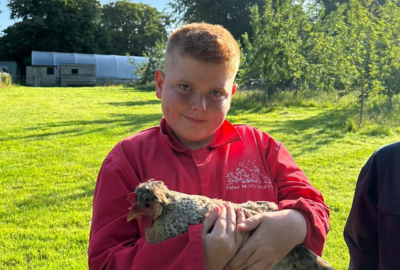 boy holding a chicken farms for city children