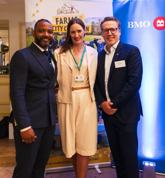 JB Gill, Corinna Csaky and Richard Couzens stood in front of a Farms for City Children banner