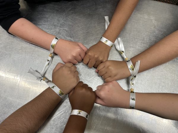 shot from above, children's hands with a wristband, in the hands are a shape of a star, connected