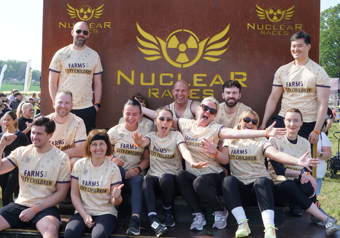 Team of runners celebrating wearing Farms for City Children tshirts