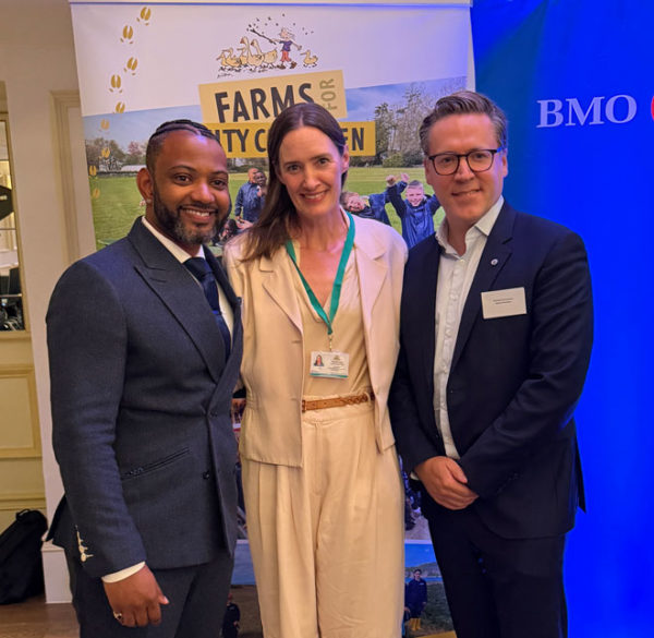 JB Gill, Corinna Csaky and Richard Couzens standing in front of a Farms for City Children and a BMO banner stand.