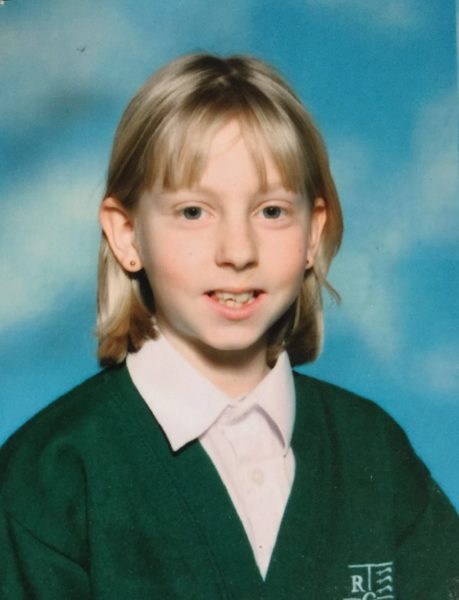 An image of Sally at primary school in her green uniform